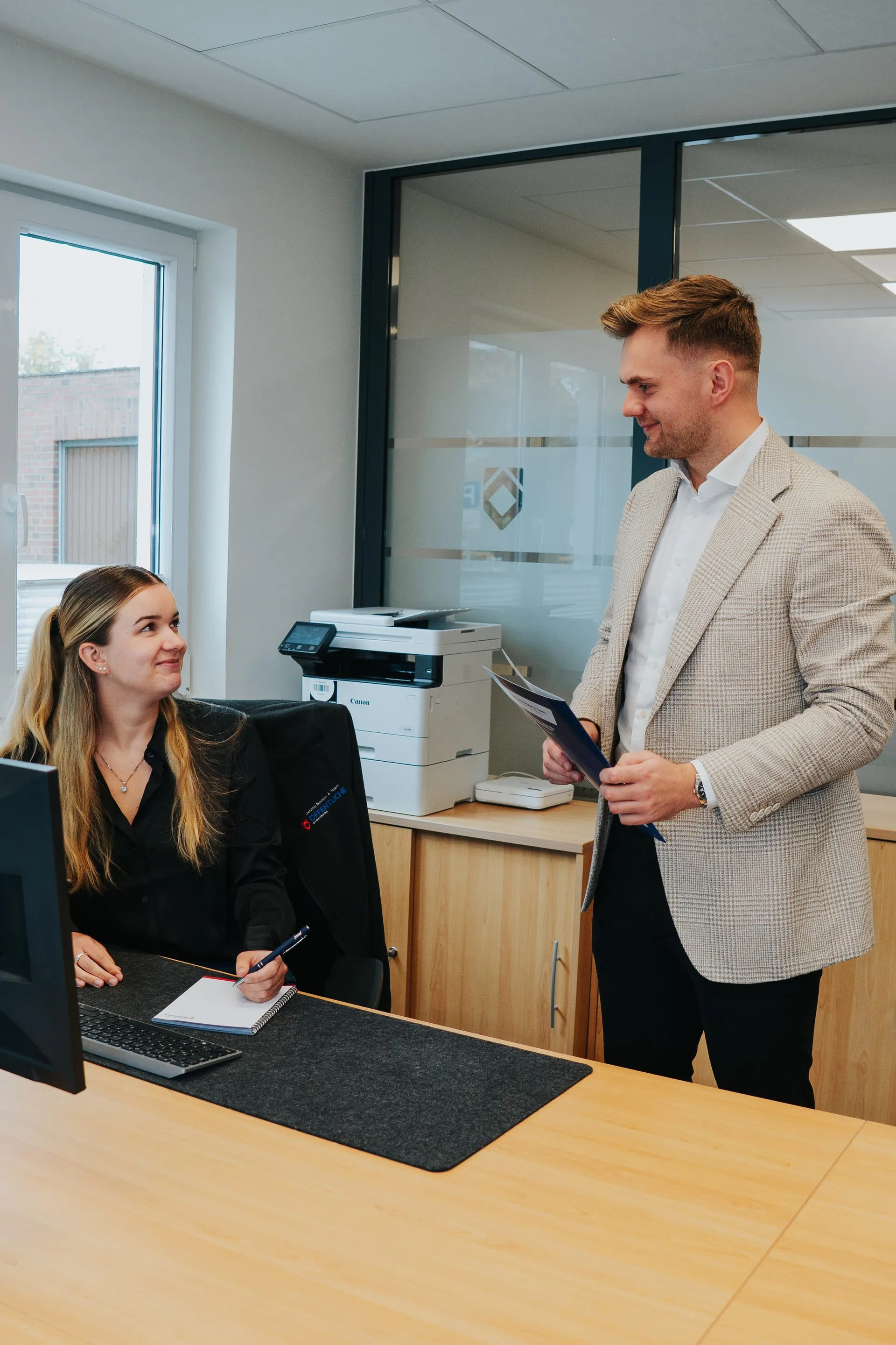 Jeremi Bockler und Mitarbeiterin Tilka lachen gemeinsam in der Agentur