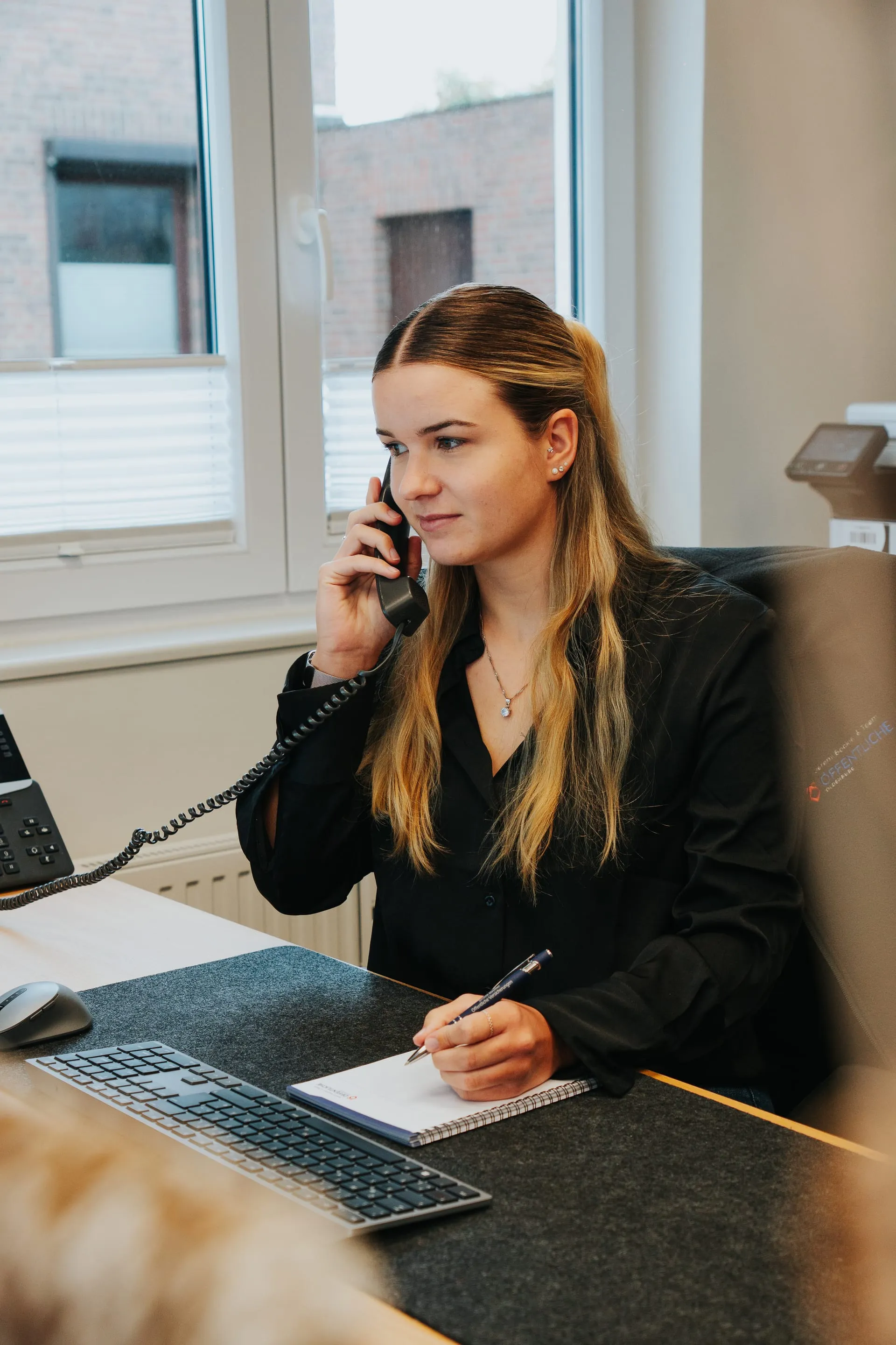 Mitarbeiterin Tilka nimmt eine Schadenmeldung am Telefon entgegen